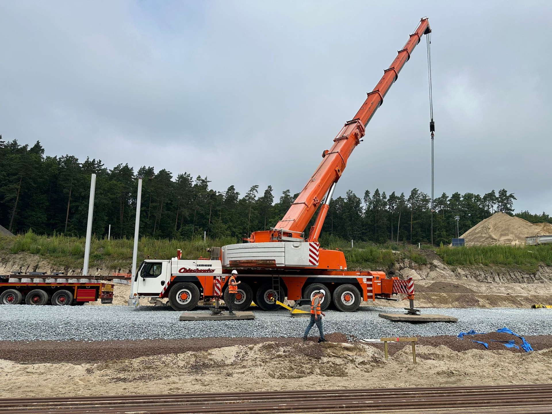 Żuraw Liebherr z wysuniętym wysięgnikiem podczas prac przy torach