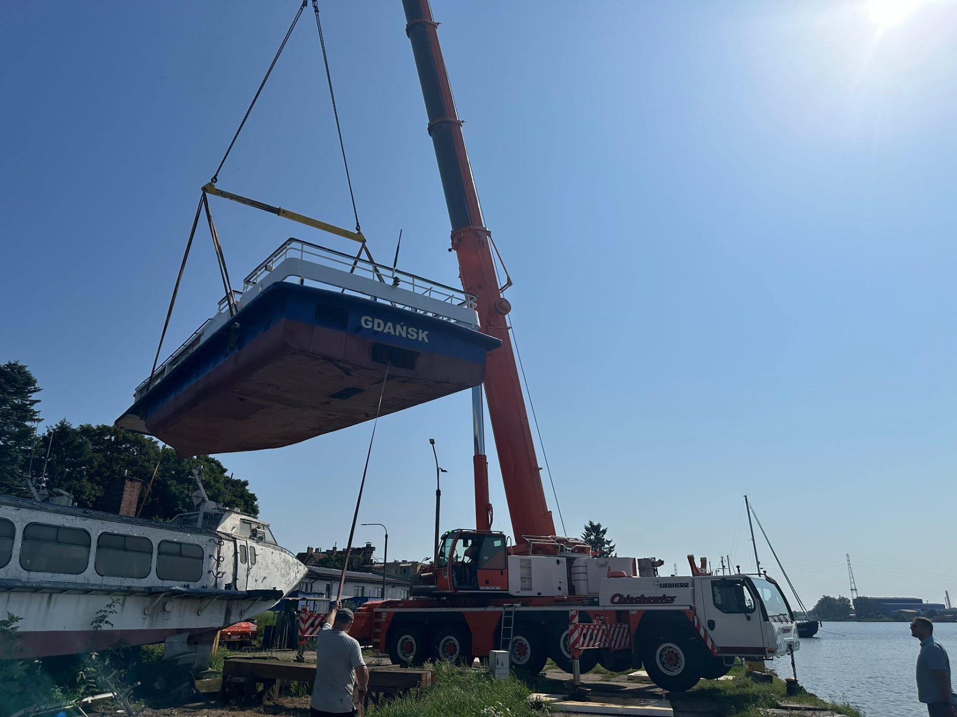 Żuraw Liebherr firmy Chlechowicz podnoszący jednostkę pływającą w porcie